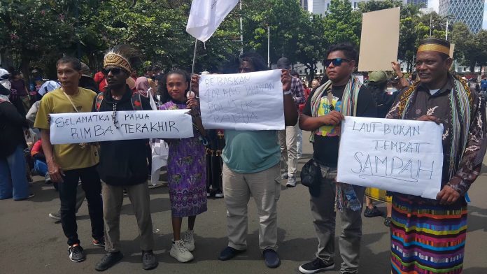 Wahana Lingkungan Hidup Indonesia (WALHI) Papua bersama Aliansi Rakyat untuk Keadilan Iklim (ARUKI) saat menggelar aksi demonstrasi menuntut pengesahan Rancangan Undang-Undang (RUU) Keadilan Iklim di kawasan Monumen Nasional (Monas), Gambir, Jakarta Pusat, Kamis (28/8/2025).